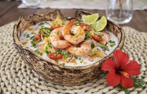 Camarones en leche de coco y jalapeño servidos en cáscara de coco